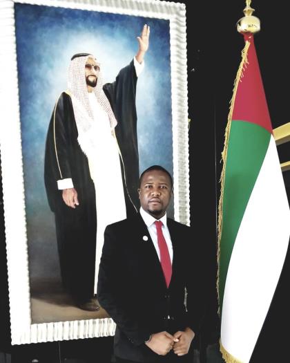 ATIGS delegate in front of the UAE flag